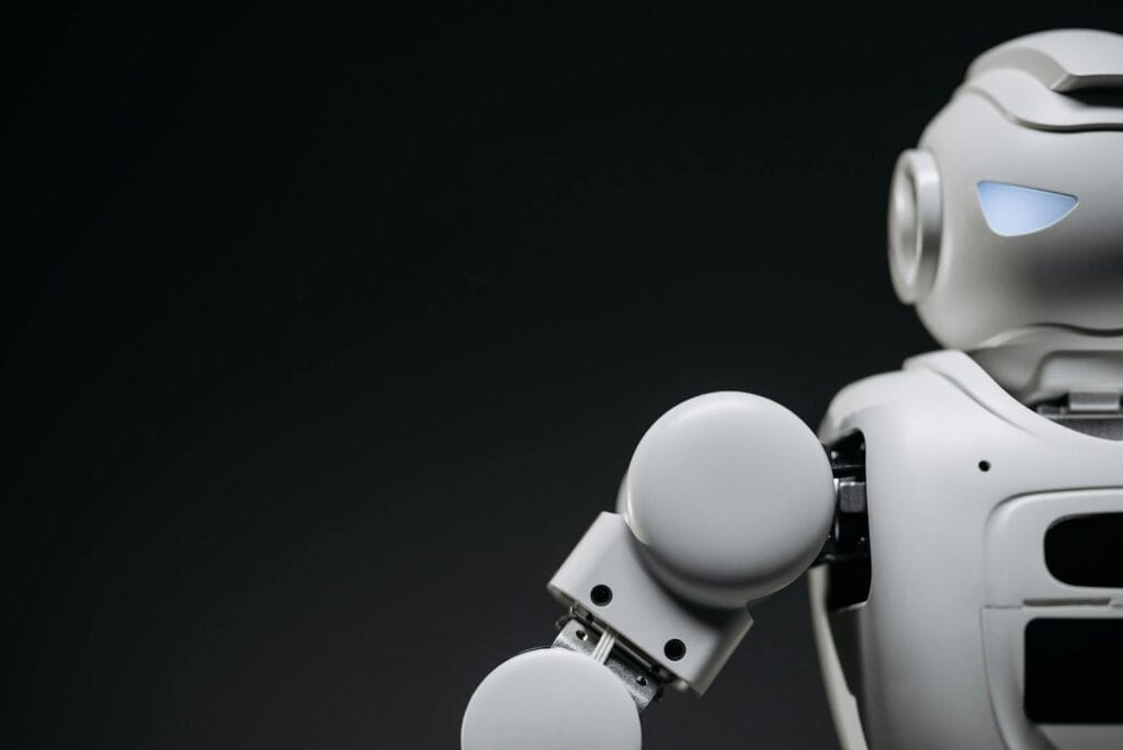 Close-up of a modern, monochrome robot arm against a dark background. Futuristic technology concept.